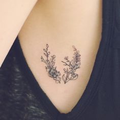 an image of a woman's back shoulder with flowers on the left side of her neck