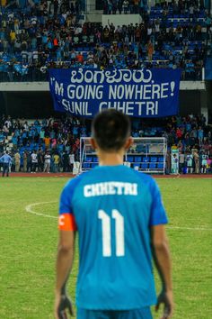 a man standing on top of a soccer field next to a blue sign that says, i'm going nowhere