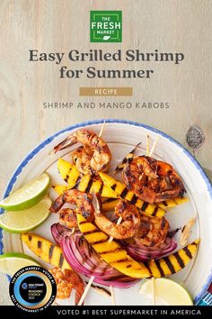 grilled shrimp and mango kabobs on a white plate with lime wedges