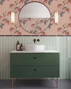 a bathroom vanity with a mirror above it next to a wallpapered wall and sink