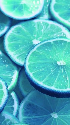 many slices of limes are shown with water droplets on them