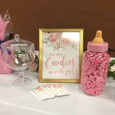 a baby shower table with pink candies in a jar and a sign that says, are you any candles up on the way?