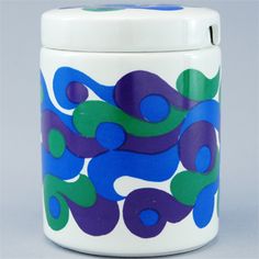 a blue and green canister sitting on top of a table