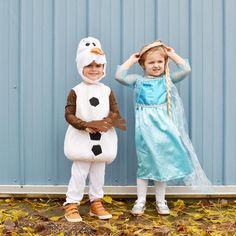 two children dressed up in costumes standing next to each other