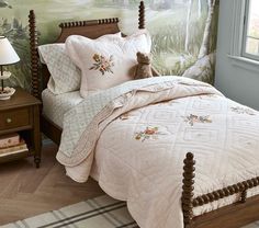 a teddy bear sitting on top of a bed in a room with green wallpaper