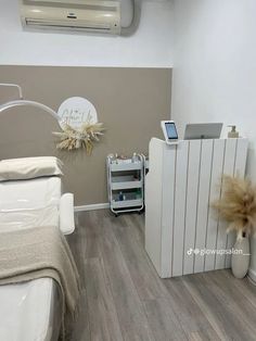 a white bed sitting next to an air conditioner in a room with wood flooring