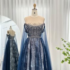 Gönnen Sie sich Luxus mit dem Abendkleid Dreamy Vow. Die eleganten Cape-Ärmel und die atemberaubende blaue Farbe strahlen Eleganz aus, perfekt für jede formelle Veranstaltung. Das arabisch inspirierte Design verleiht eine einzigartige Note. Setzen Sie bei Ihrer nächsten Hochzeitsfeier oder Ihrem nächsten Abschlussball ein Statement. Evening Dress With Cape, Dress With Cape Sleeves, Arabic Women, Elegant Cape, Elements Of Drama, Blue Evening Dress, Dress With Cape, Blue Evening Dresses, Cape Sleeves