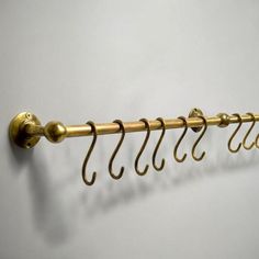 a gold coat rack with five hooks hanging from it