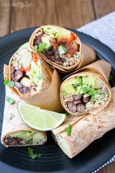 several burritos are stacked on top of each other with avocado and black beans