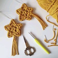 crochet supplies including scissors, yarn and thread laid out on a white surface