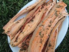 a white plate topped with sliced up carrots on top of green grass covered ground