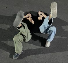 two people laying on the ground with their feet in the air and one person wearing white shoes