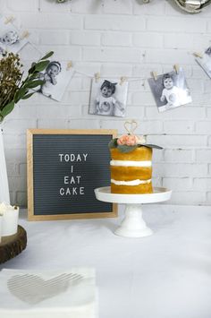 a cake sitting on top of a white table next to a sign that says today i eat cake