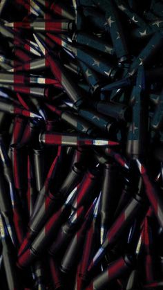 an american flag made out of baseball bats and crayons on a black background