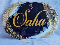 a black and gold plate with the word saha's on it