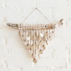 a wooden wind chime hanging on a brick wall