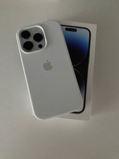 an iphone 11 pro in its box on a white table with it's back facing the camera