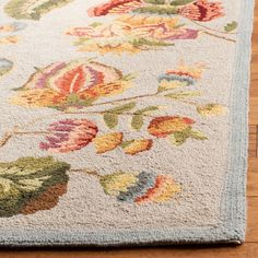 a rug with flowers and leaves on the floor in front of a wood flooring area