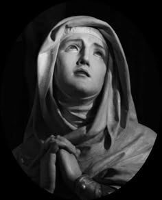 black and white photograph of a woman with her head covered by a scarf looking up