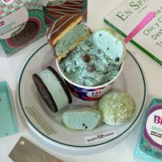 an ice cream sundae with cookies and other desserts on a white table top