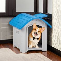 a corgi dog sitting in its kennel at the entrance to his house