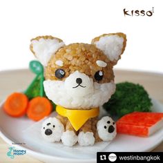 a small stuffed animal is sitting on a plate with carrots and broccoli