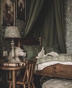 a bedroom with green wallpaper and pictures on the walls, including a small bed