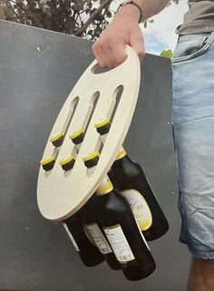 a man holding a rack with six bottles in it