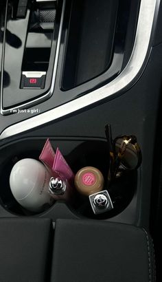 the interior of a car with various items in its storage compartment, including makeup and eyeliners