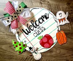 a welcome sign with paper cutouts and bows around it on a wooden table top