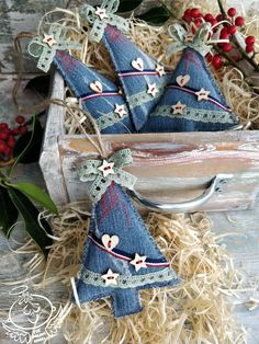 two small blue christmas trees in a wooden box with red berries and greenery on the side