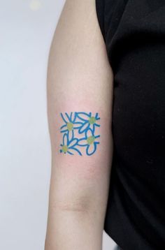 a woman with a tattoo on her arm that has blue and green designs on it