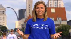 a woman wearing a saint louis university t - shirt in front of the st louis arch