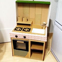 a cardboard toy stove and sink in a kitchen