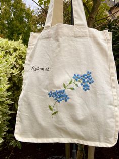 This hand embroidered floral tote bag is perfect for just about anything. It is great to bring to the market, for groceries, going to the beach or carrying around your usual goods. This tote bag is a standard cotton, light cream coloured canvas. The bag comes with an ironed on backing to protect the design from being snagged by belongings inside the bag.  This tote bag can hold a good amount of weight like a laptop, books, water bottle and all you need for the day! Embroidered Totes, Embroidered Cotton Eco-friendly Bags, Eco-friendly Embroidered Cotton Bags, Handmade Spring Canvas Tote Bag, Cotton Bag With Floral Embroidery As Gift, Daily Use Cotton Canvas Bag With Floral Embroidery, Eco-friendly Embroidered Cotton Canvas Bag, Beige Cotton Bag With Floral Embroidery, Decorate Tote Bag