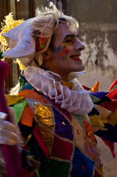 a man dressed in colorful clothing and makeup