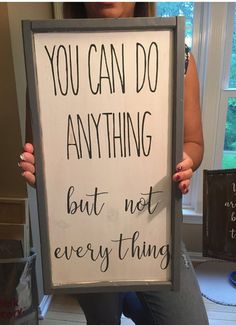 a woman holding up a sign that says you can do anything but not every thing