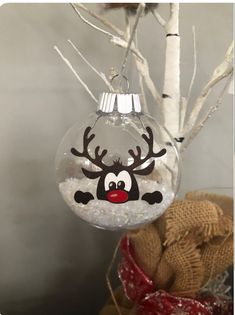 a christmas ornament hanging from a tree with reindeer's head on it