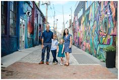 a family standing in front of a colorful wall