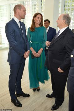 two men and a woman in business attire standing next to each other with one holding the other's hand