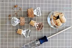 there are some wine corks on the table next to a glass bottle and a wooden stick