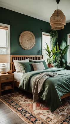 a bed with green sheets and pillows in a room next to two windows, potted plants on the wall