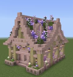 a house made out of bricks with purple flowers growing on the roof