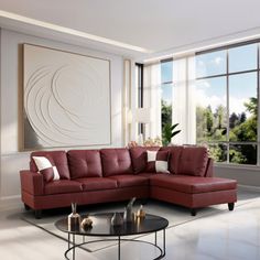 a living room with a red couch and table in front of large windows overlooking trees