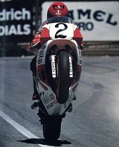 a person riding a motorcycle on a race track in front of a sign that reads 2