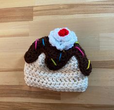 a small crocheted purse with a red and white flower on it's top