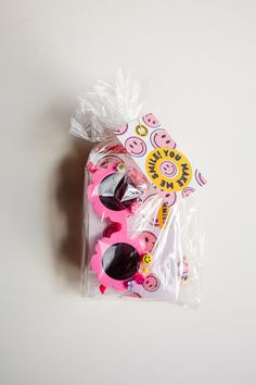 a plastic bag filled with pink and black sunglasses on top of a white countertop