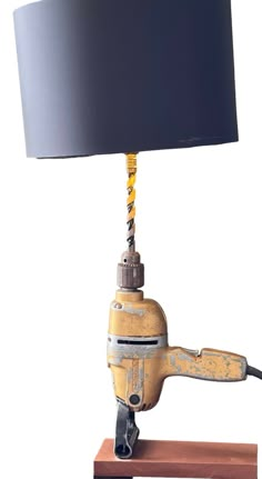 a lamp that is sitting on top of a wooden block with a black shade over it