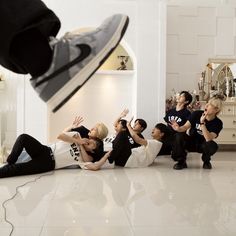 a group of young people sitting on the floor in front of a person jumping up into the air