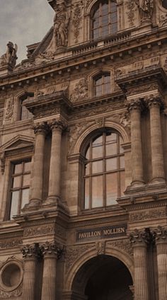 an old building with a clock on the top of it's face and windows